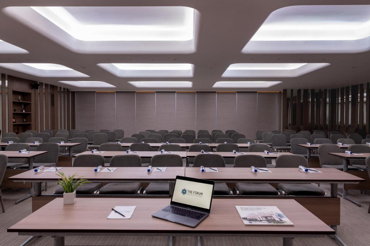 a large room with tables and chairs and a laptop at Wyndham Ahmedabad Shela in Ahmedabad