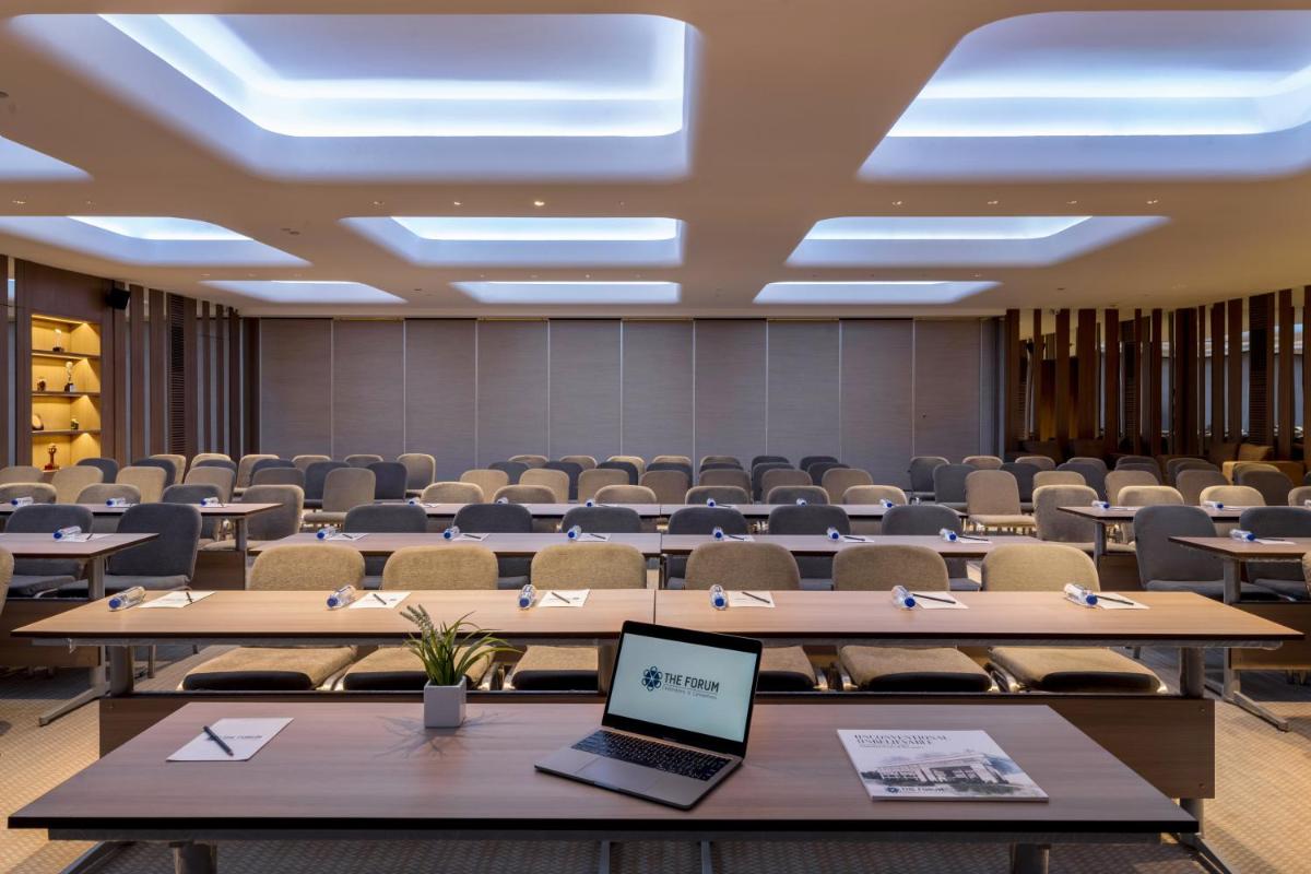 a room with tables and chairs and a laptop on a table at Wyndham Ahmedabad Shela in Ahmedabad