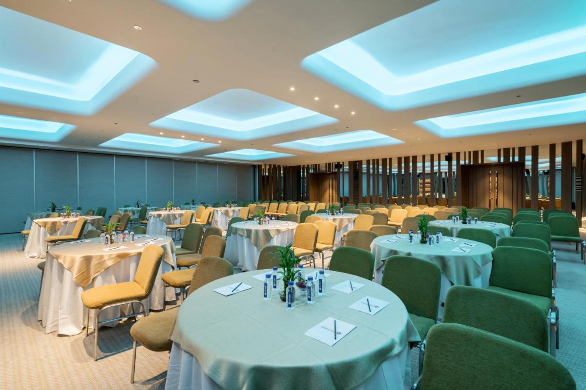 a banquet hall with white tables and chairs at Wyndham Ahmedabad Shela in Ahmedabad