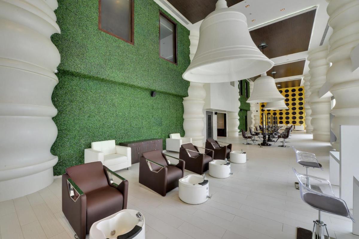 a lobby with chairs and a green wall at Wyndham Ahmedabad Shela in Ahmedabad