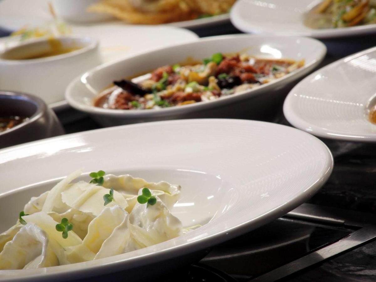 a plate of dumplings with other dishes on a table at Novotel Chennai Chamiers Road in Chennai