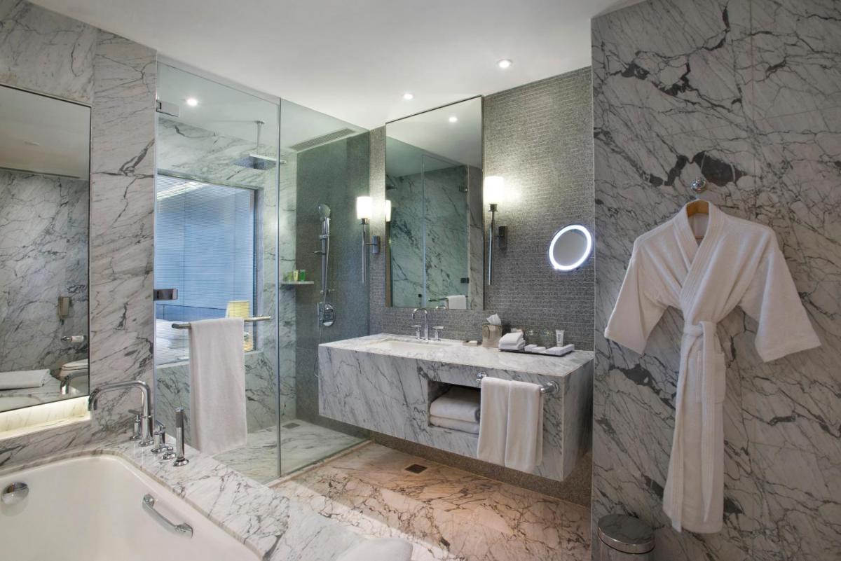 a bathroom with a bath tub and a sink and a bath tub at Hyatt Regency Gurgaon in Gurgaon