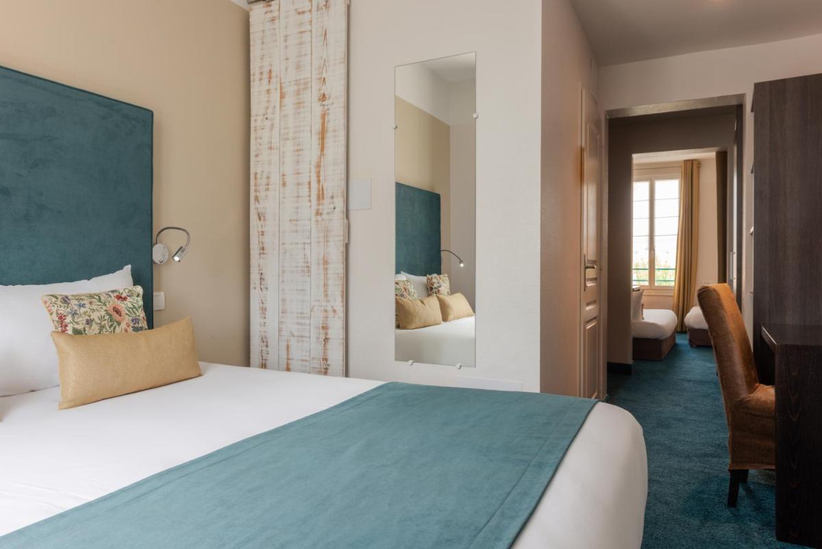 Un ou plusieurs lits dans un hébergement de l'établissement The Originals Boutique Hôtel La Villa Ouest & Spa