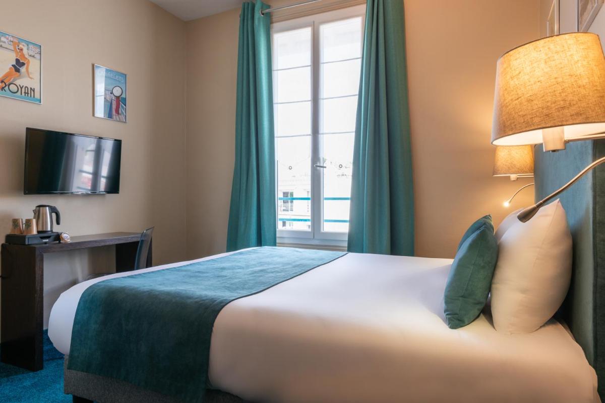 Un ou plusieurs lits dans un hébergement de l'établissement The Originals Boutique Hôtel La Villa Ouest & Spa