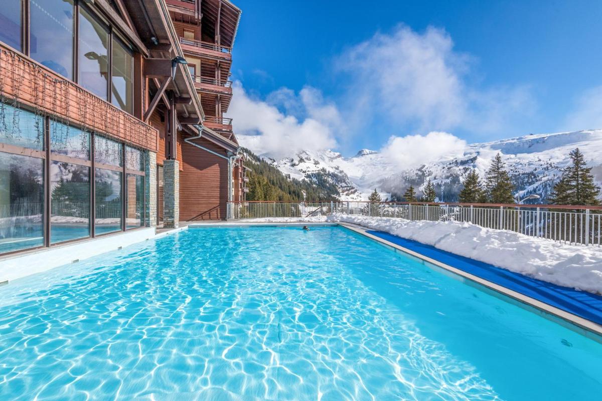 une piscine avec des montagnes enneigées en arrière-plan dans l'établissement Résidence Pierre & Vacances Premium Les Terrasses d'Eos, à Flaine