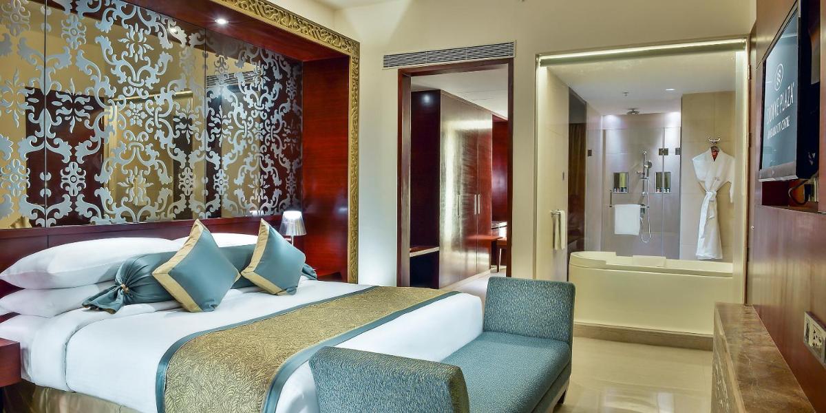 a hotel room with a bed and a chair at Crowne Plaza Ahmedabad City Centre by IHG in Ahmedabad