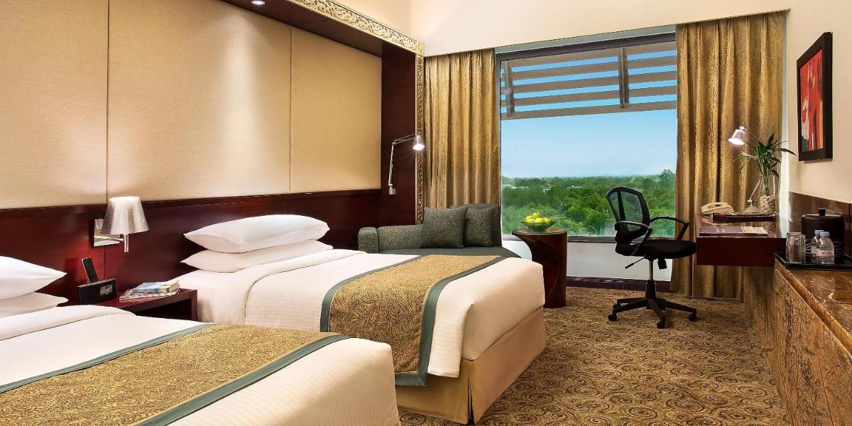 a hotel room with two beds and a window at Crowne Plaza Ahmedabad City Centre by IHG in Ahmedabad