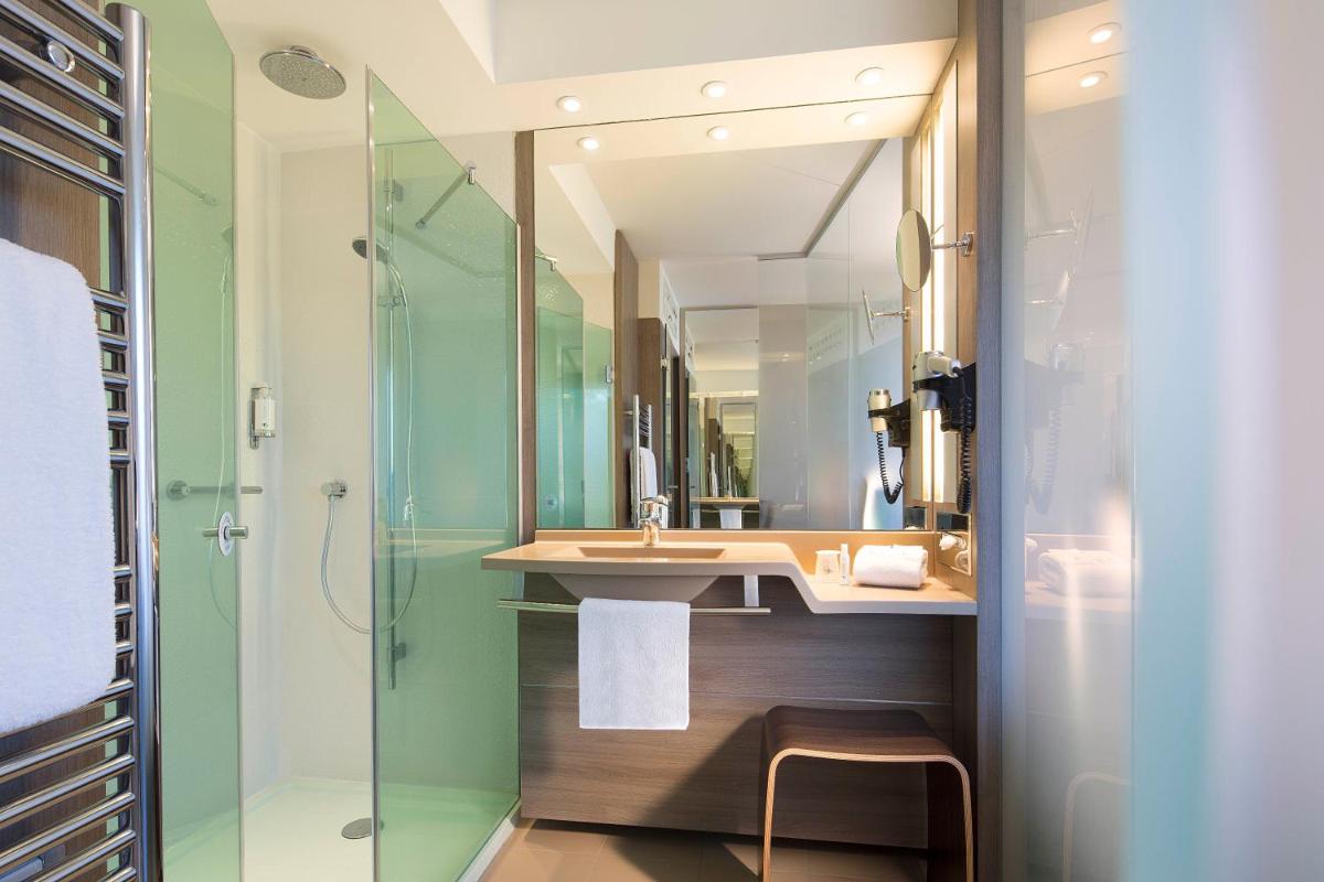 une salle de bain avec un lavabo et une douche dans l'établissement Oceania Clermont Ferrand, à Clermont-Ferrand 29 autres photos