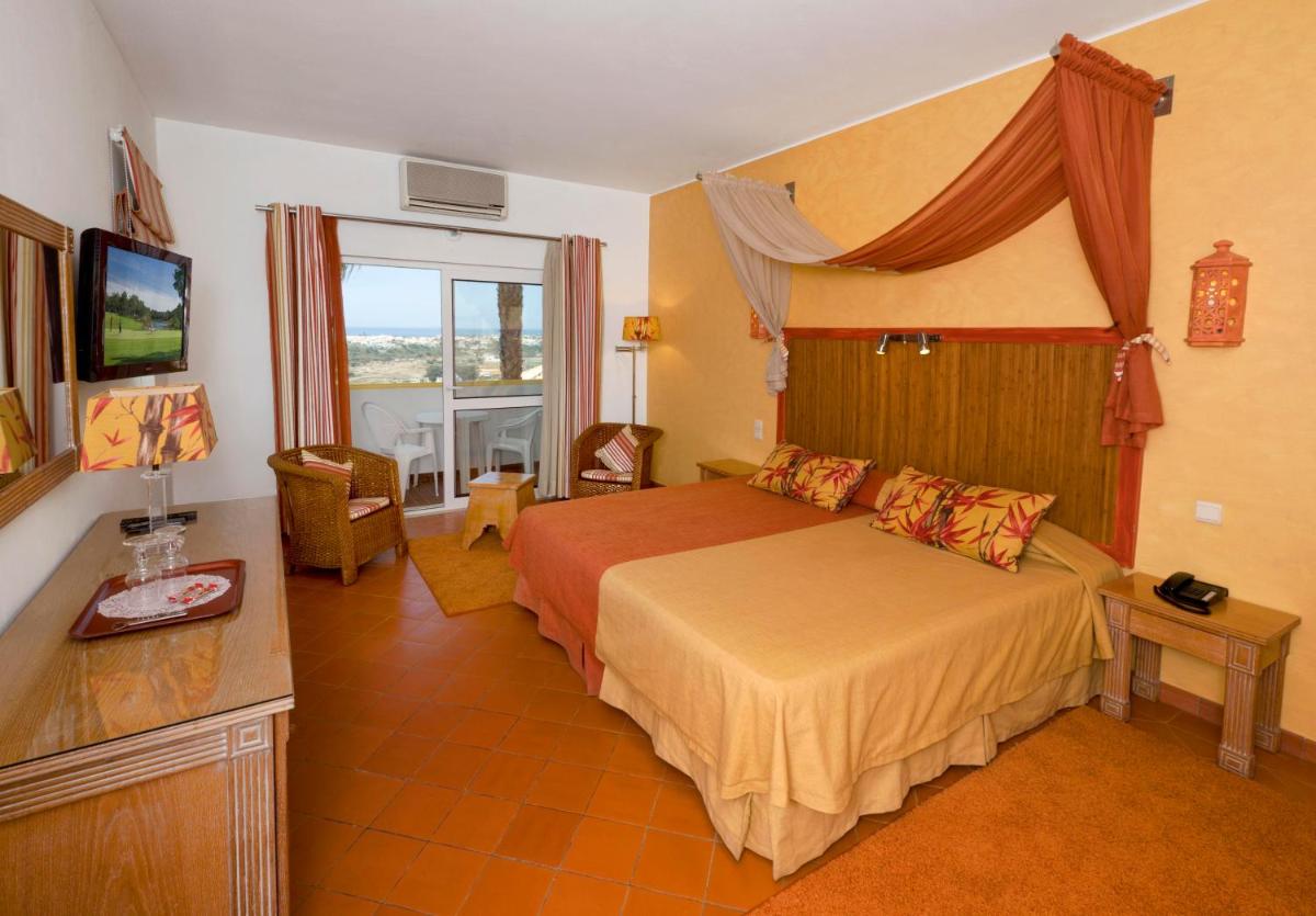um quarto de hotel com uma cama e uma televisão em Cerro Da Marina Hotel - Adults Only em Albufeira