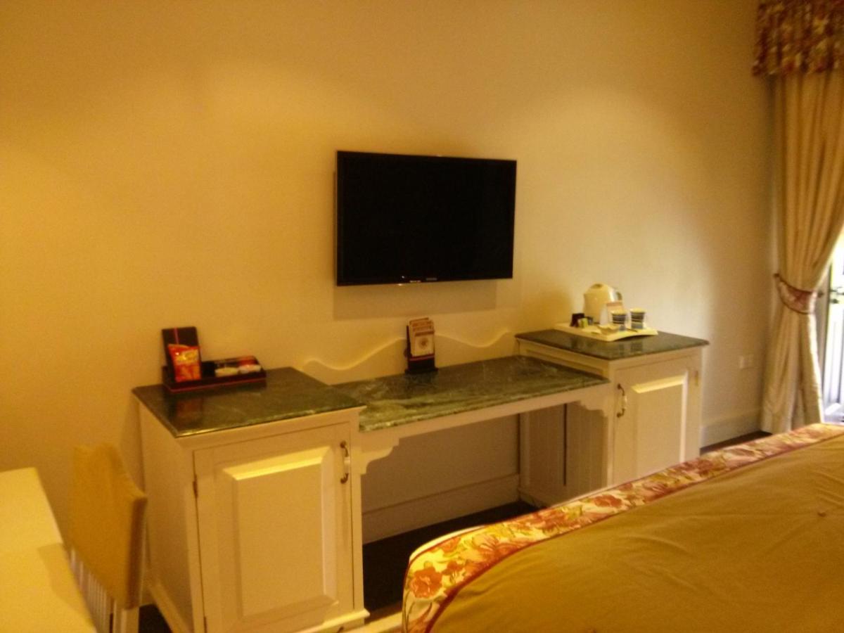 a room with a desk with a television on a wall at Welcomhotel by ITC Hotels, The Savoy, Mussoorie in Mussoorie