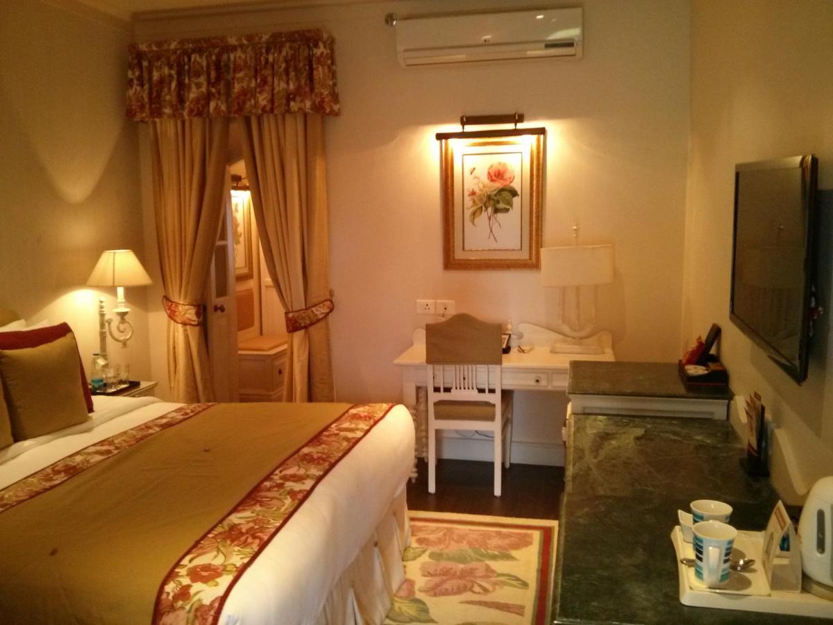a hotel room with a bed and a desk at Welcomhotel by ITC Hotels, The Savoy, Mussoorie in Mussoorie