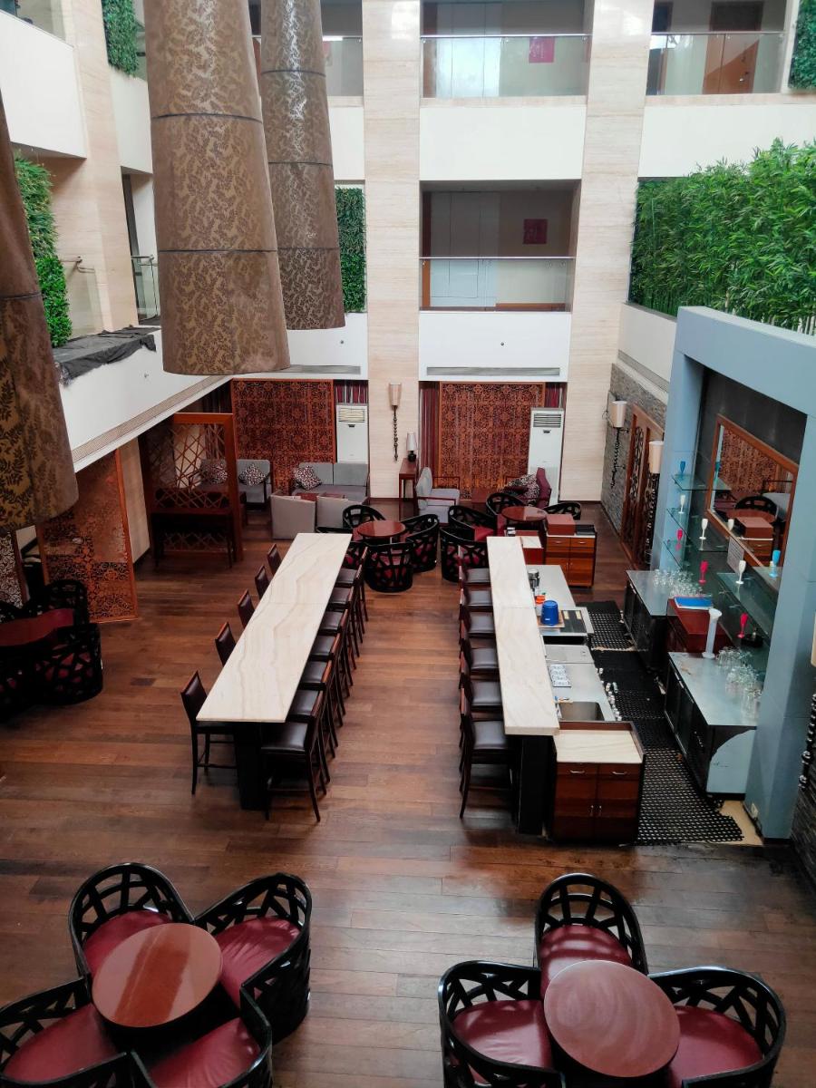 a large room with tables and chairs in a building at Pride Plaza Hotel, Kolkata in Kolkata