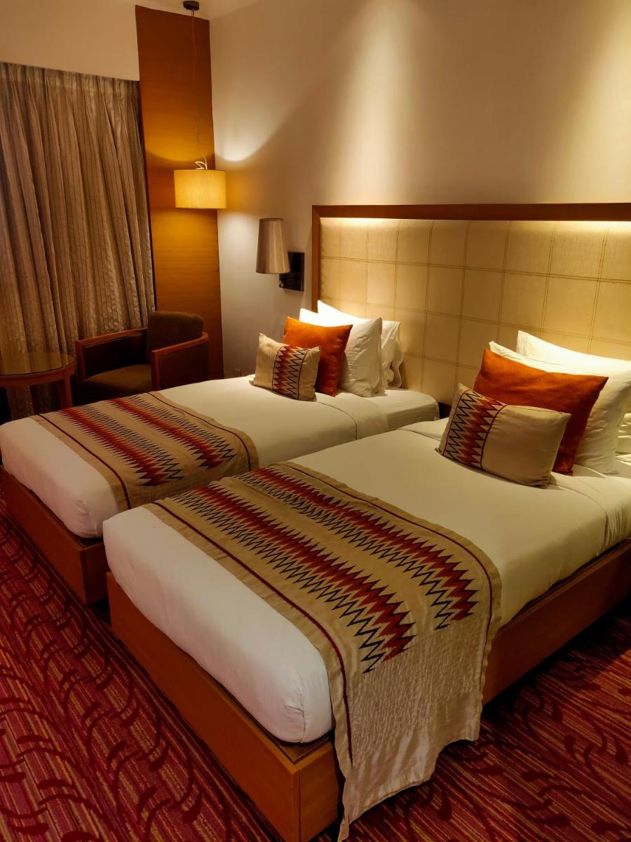 a hotel room with two beds in a room at Pride Plaza Hotel, Kolkata in Kolkata