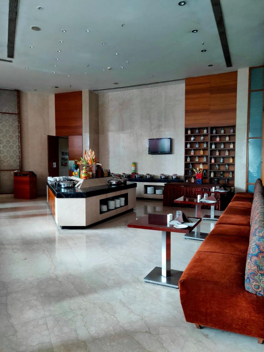 a living room with a couch and a table at Pride Plaza Hotel, Kolkata in Kolkata