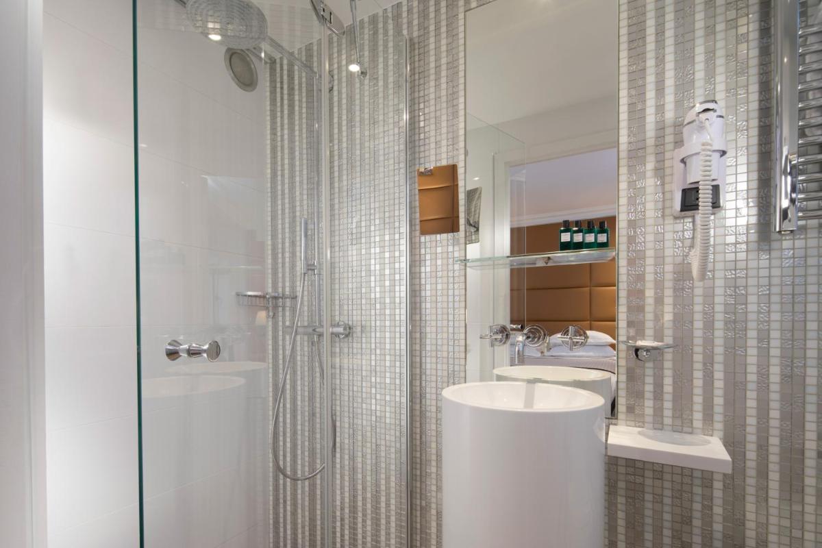 une salle de bain avec deux lavabos et une douche en verre dans l'établissement Hôtel R de Paris - Boutique Hotel, à Paris 43 autres photos