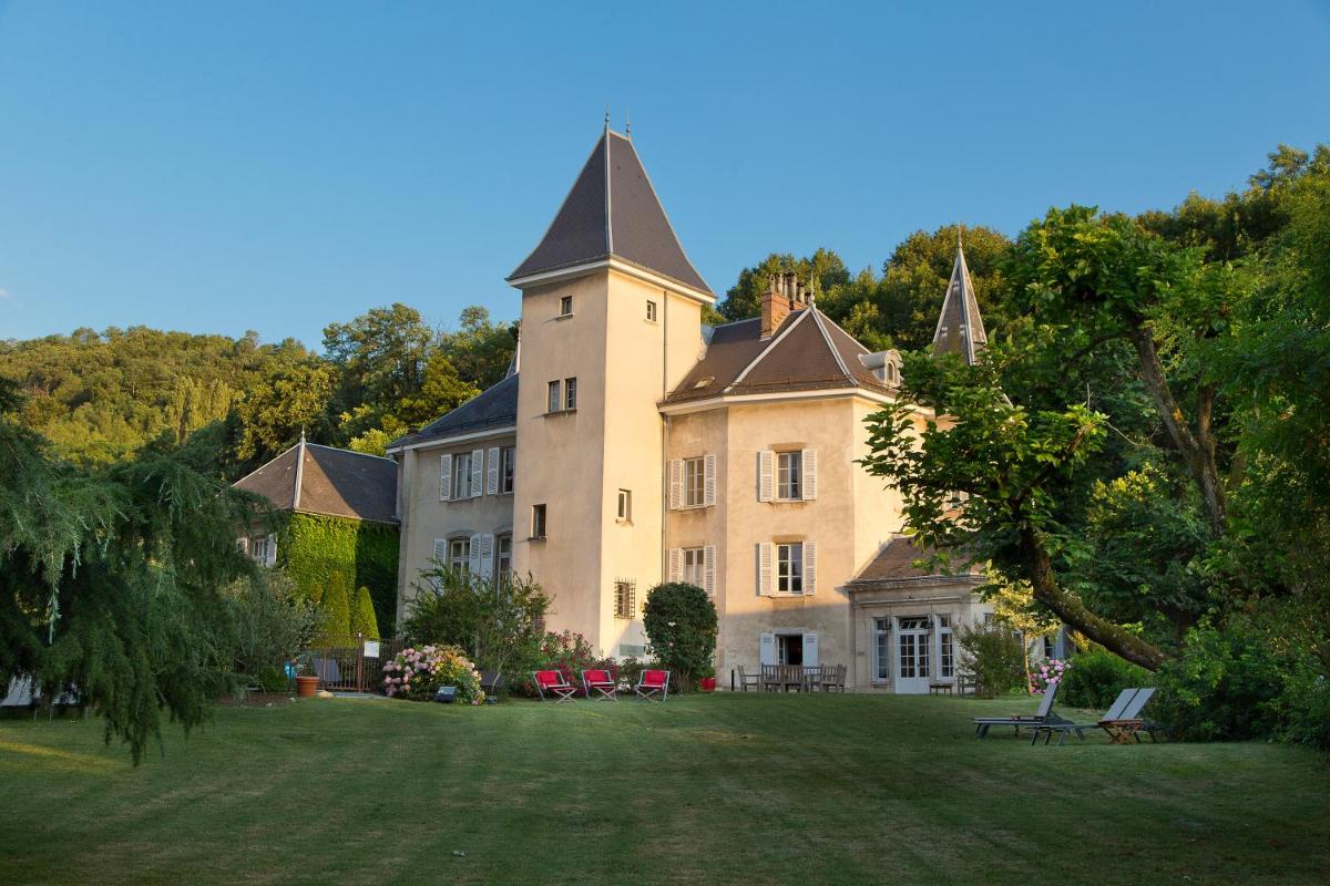 un grand bâtiment avec une tour sur une pelouse dans l'établissement Château Hôtel, Restaurant & Spa De La Commanderie, à Eybens