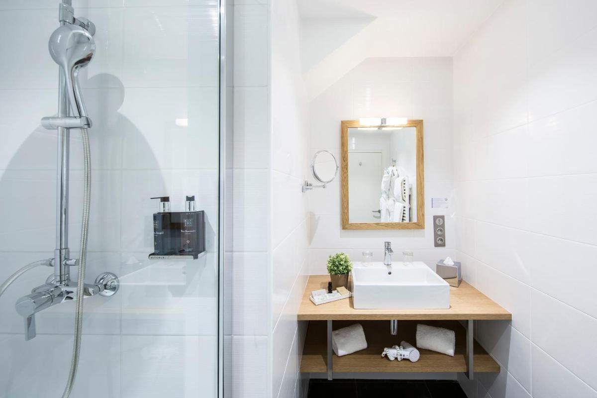 une salle de bain avec lavabo et douche dans l'établissement Hotel de L'Abbaye Le Tronchet - Handwritten Collection, au Tronchet