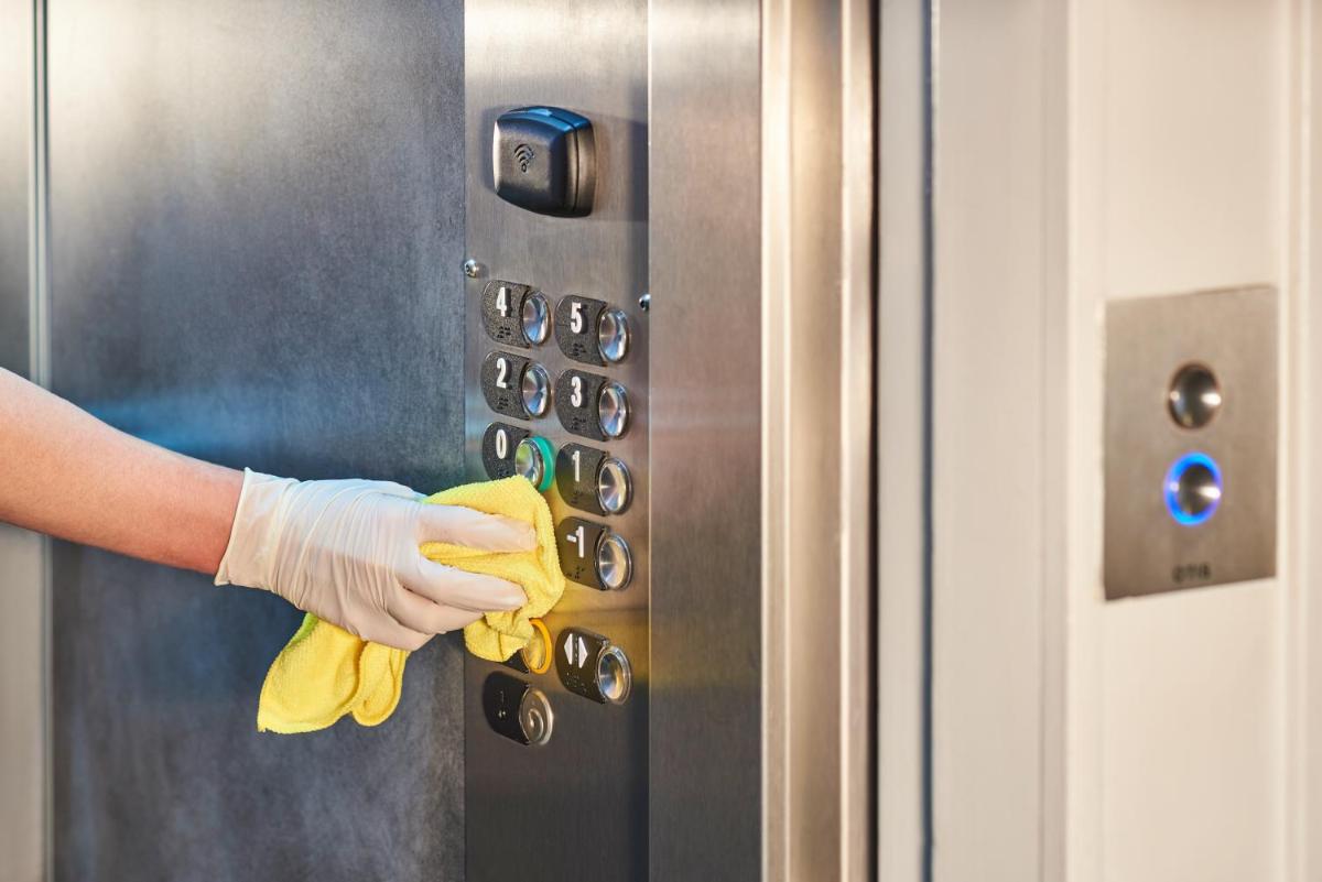 a person wearing a glove is cleaning an elevator at Novotel Chennai Chamiers Road in Chennai