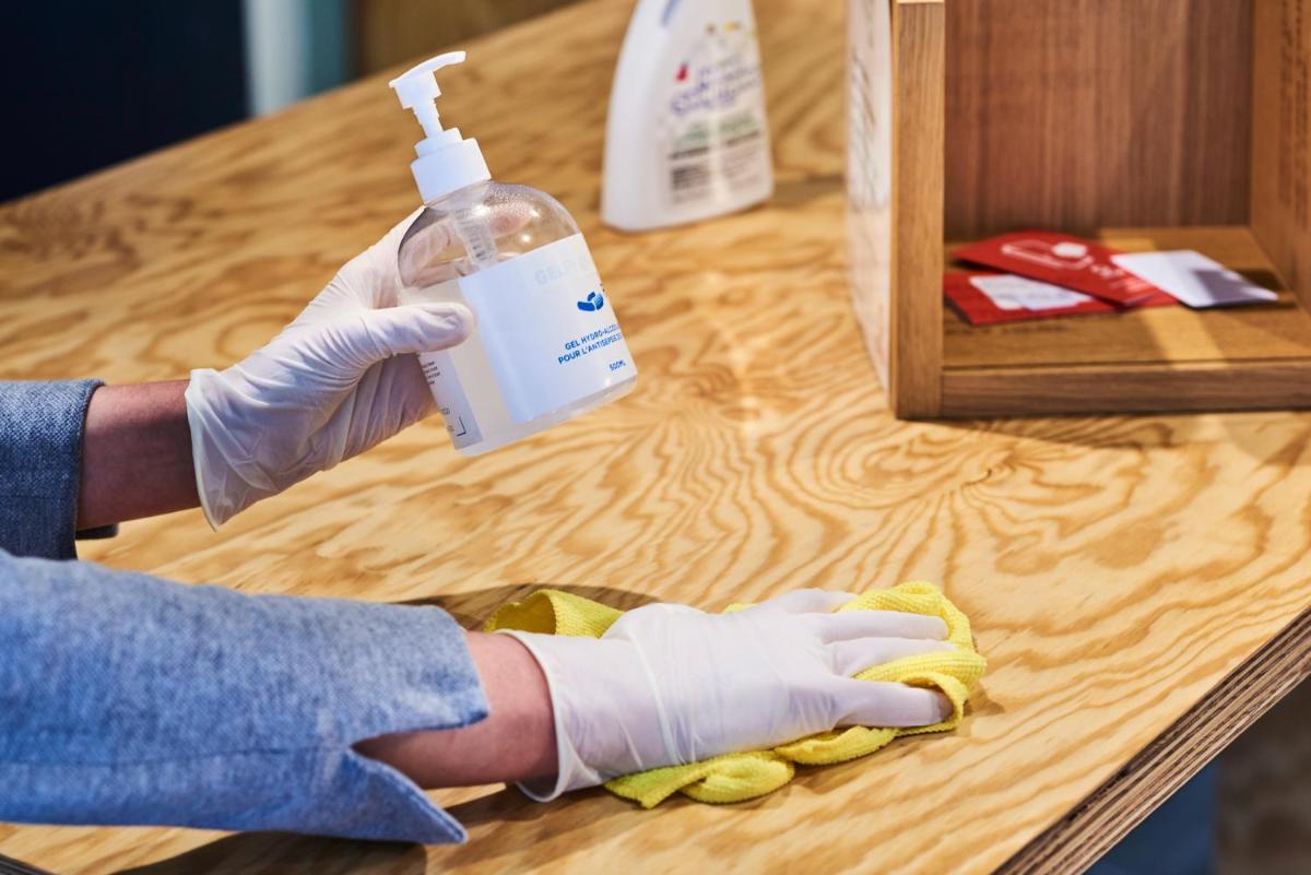 a person in gloves holding a bottle on a table at Novotel Chennai Chamiers Road in Chennai