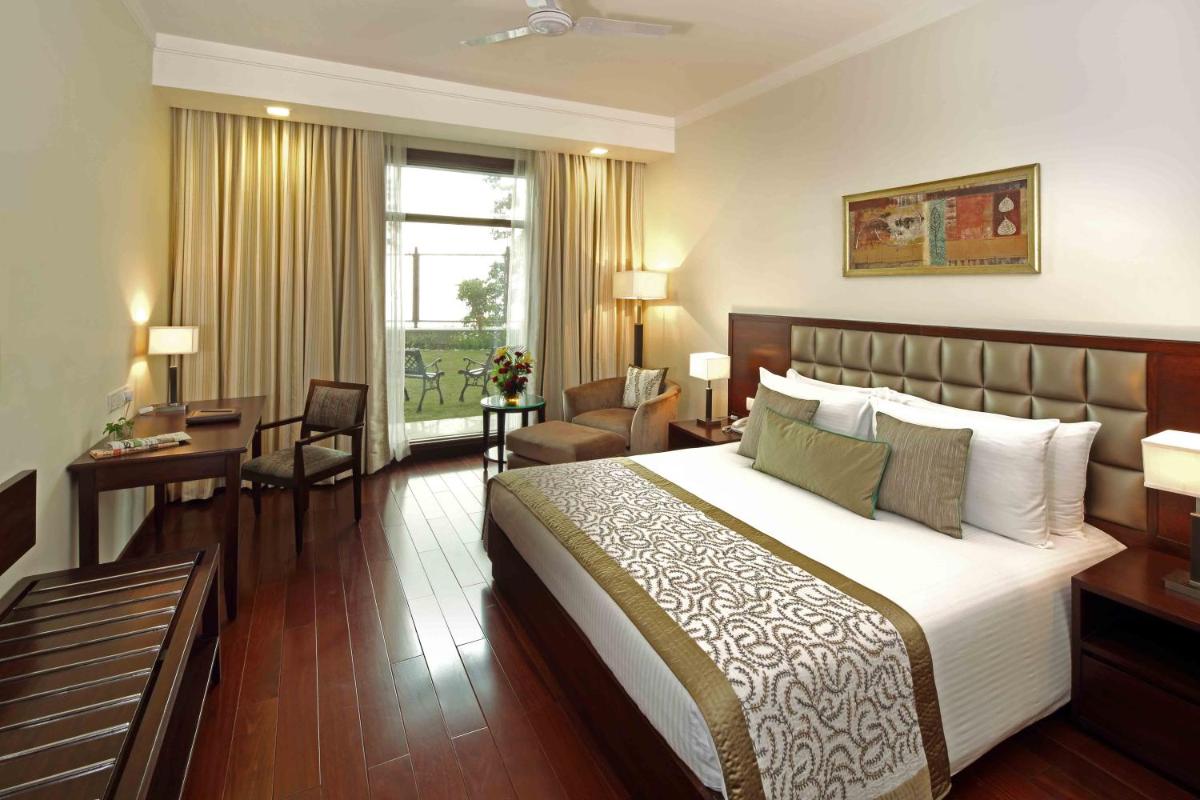 a hotel room with a large bed and a desk at Jaypee Residency Manor in Mussoorie