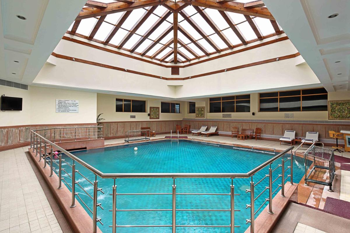 a large swimming pool in a building with a large ceiling at Jaypee Residency Manor in Mussoorie