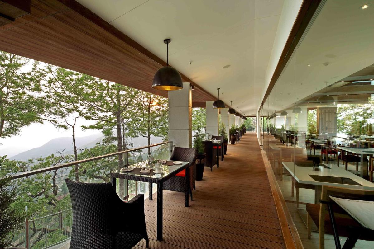 a restaurant with tables and chairs on a balcony at Jaypee Residency Manor in Mussoorie