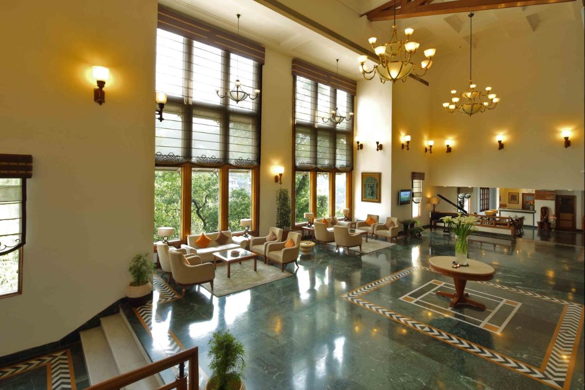a large lobby with chairs and tables and windows at Jaypee Residency Manor in Mussoorie