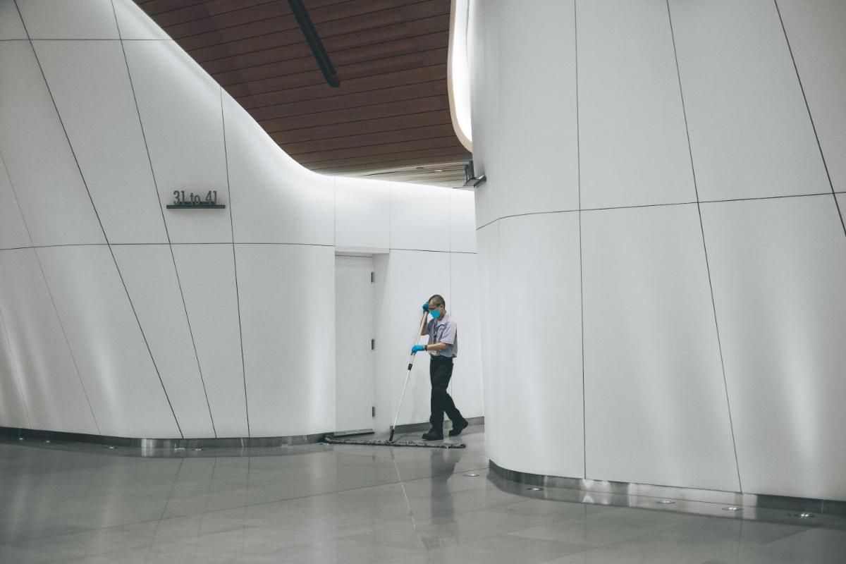a man standing in a hallway with a mop at Novotel Kochi Infopark in Cochin