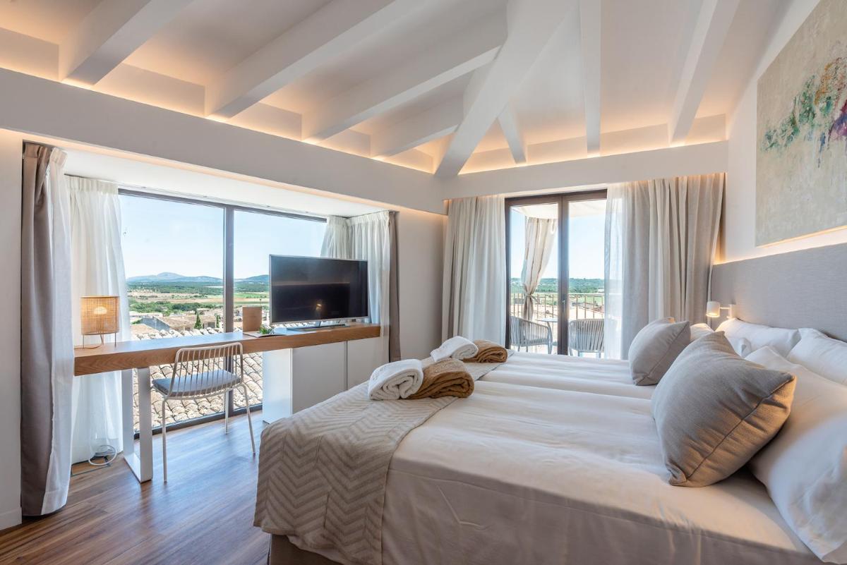 Un dormitorio con una cama grande con una ventana grande. en Ynaira hotel & Spa, en Ariany