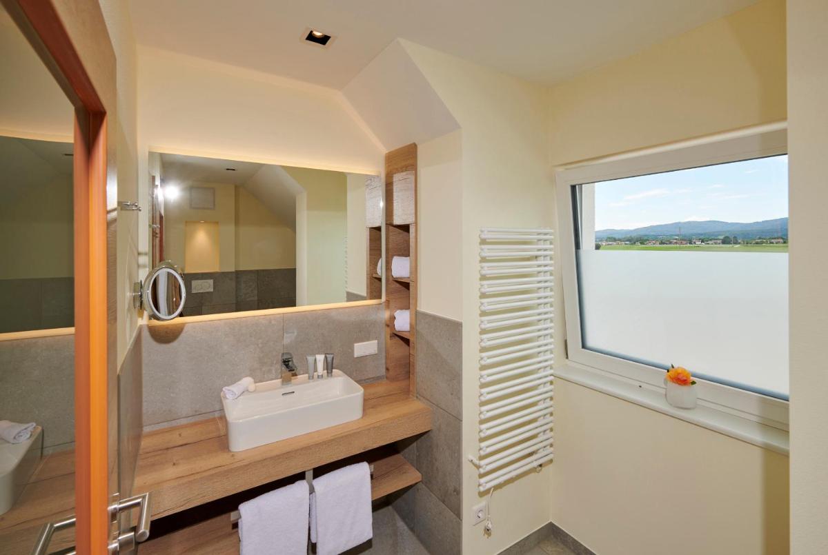 ein Badezimmer mit Waschbecken und großem Fenster in der Unterkunft Bachhof Resort Apartments in Kirchroth + 26 Fotos