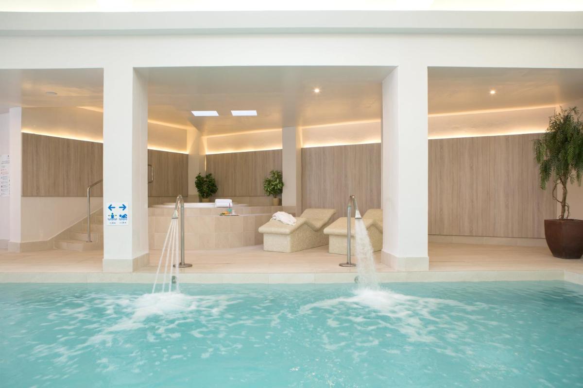 vestíbulo del hotel con piscina y sala de estar en Hotel Sabina, en Cala Millor