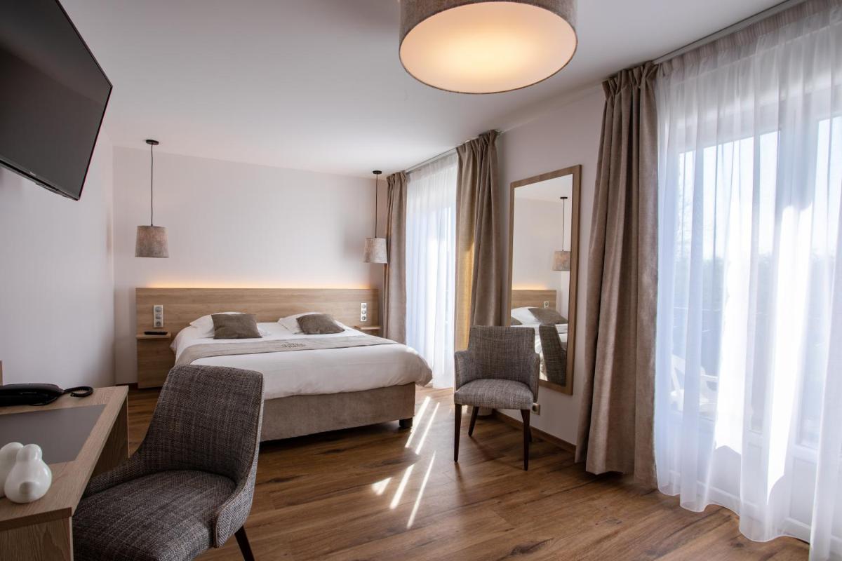 une chambre avec un lit, un bureau et un miroir dans l'établissement Hôtel SPA du Lac de Madine - Maison DRAPIER, à Heudicourt-sous-les-Côtes