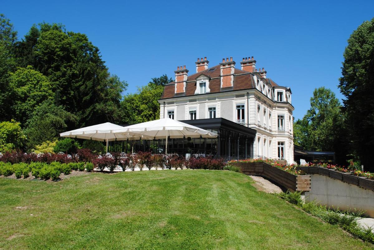 une grande maison blanche avec une pelouse devant dans l'établissement Château de La Dame Blanche - Logis, à Geneuille