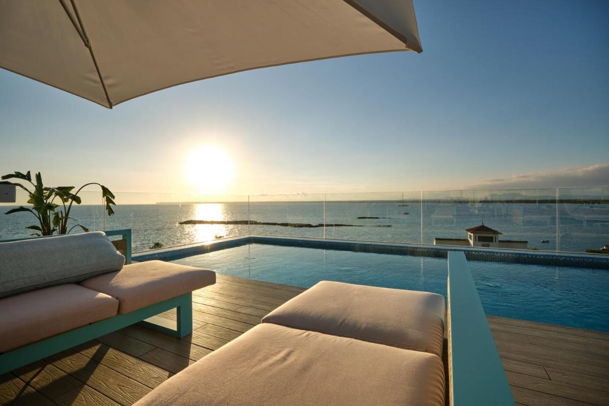 una piscina con sofá y cama y el océano en Hotel Villa Chiquita - Adults Only - Over 12, en Colonia de Sant Jordi