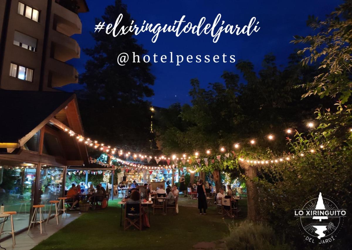 un grupo de personas sentadas en mesas bajo una serie de luces en Hotel Restaurant Pessets & SPA, en Sort 70 fotos más