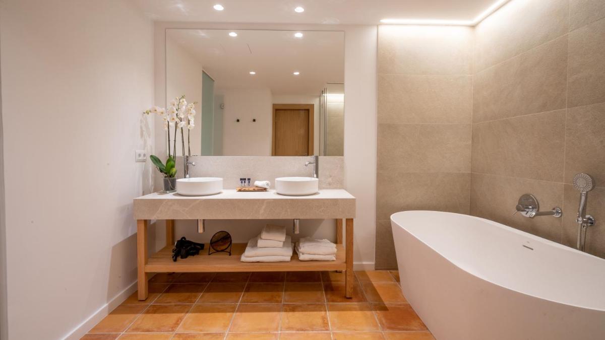 Un baño con bañera, lavabo y espejo. en Mon Port Hotel & Spa, en Puerto de Andratx