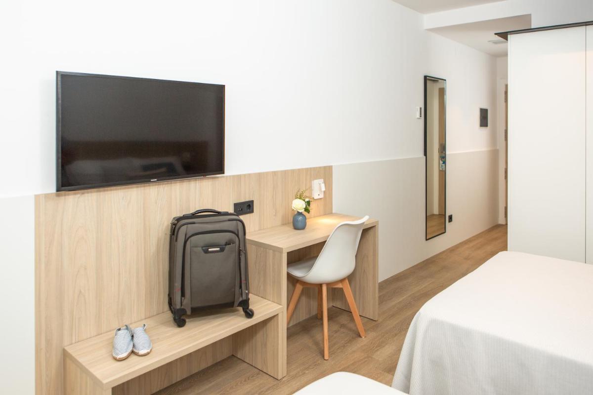 Habitación con mochila y escritorio con TV. en RVHotels Ametlla Mar, en L'Ametlla de Mar