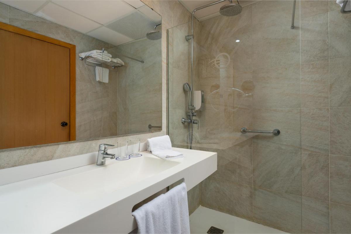 un baño con lavabo y ducha en Hotel Torre Azul & Spa - Adults Only, en El Arenal