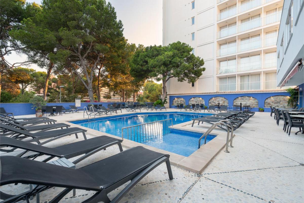 una piscina con tumbonas junto a un edificio en Hotel Torre Azul & Spa - Adults Only, en El Arenal