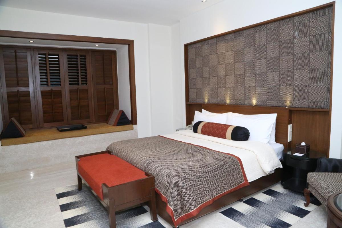 a bedroom with a large bed and a window at The Lalit Great Eastern Kolkata in Kolkata a bedroom with a large bed and a window at The Lalit Great Eastern Kolkata in Kolkata