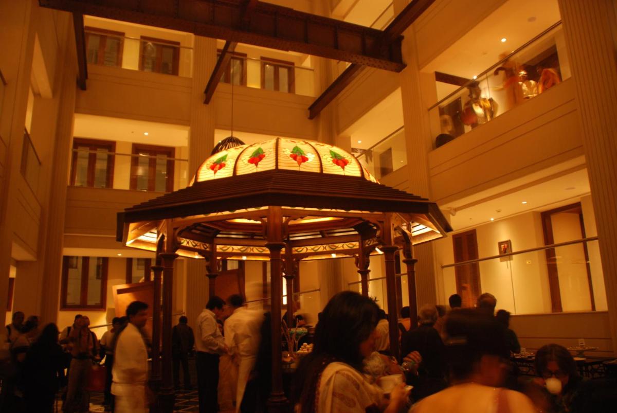 a group of people standing around a carousel in a building at The Lalit Great Eastern Kolkata in Kolkata a group of people standing around a carousel in a building at The Lalit Great Eastern Kolkata in Kolkata