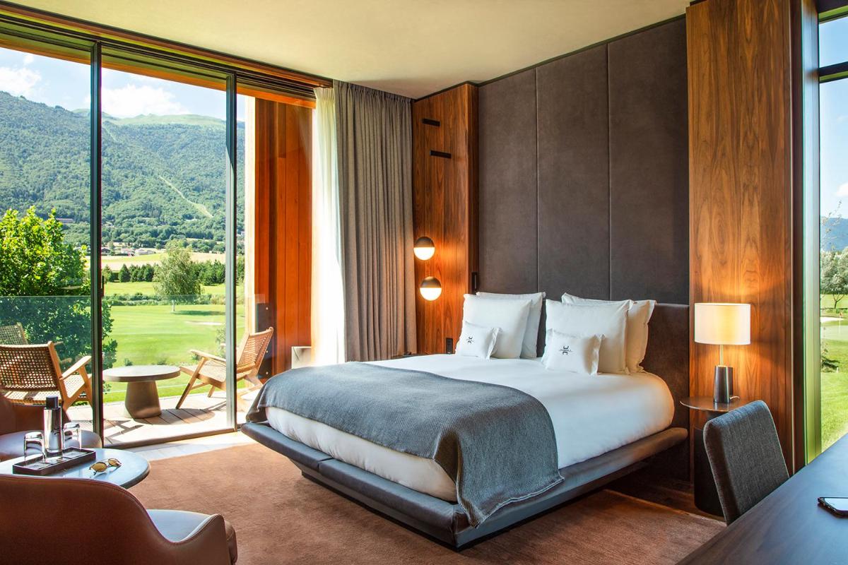 une chambre avec un grand lit et une grande fenêtre dans l'établissement Jiva Hill Resort - Genève, à Crozet
