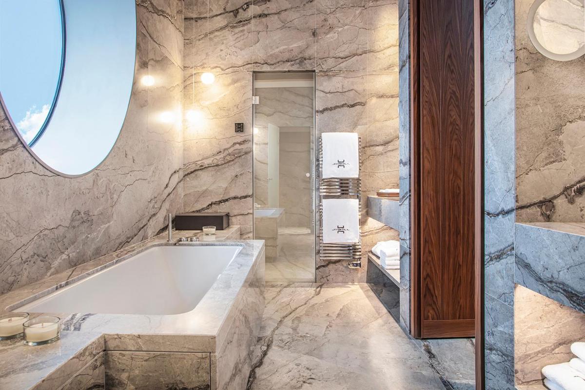une salle de bains avec baignoire et douche en verre dans l'établissement Jiva Hill Resort - Genève, à Crozet