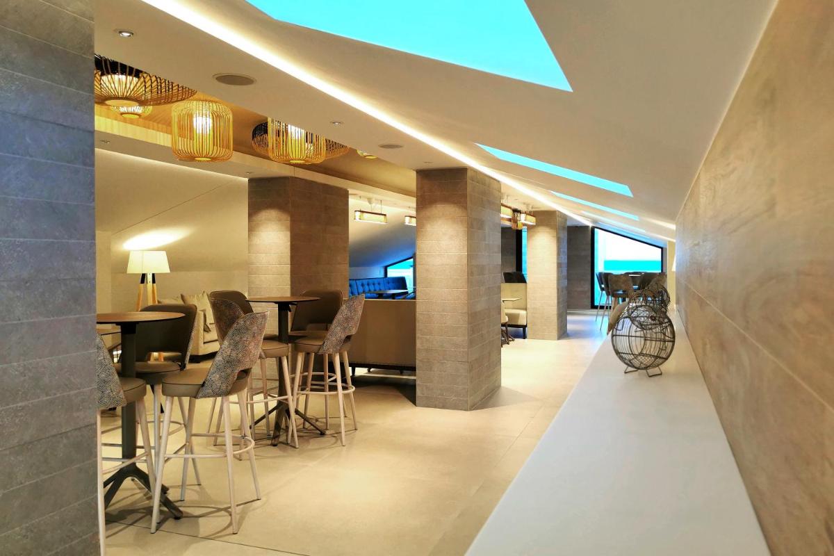 Una sala de estar con sillas y un comedor. en Hotel Acuazul, en Peñíscola
