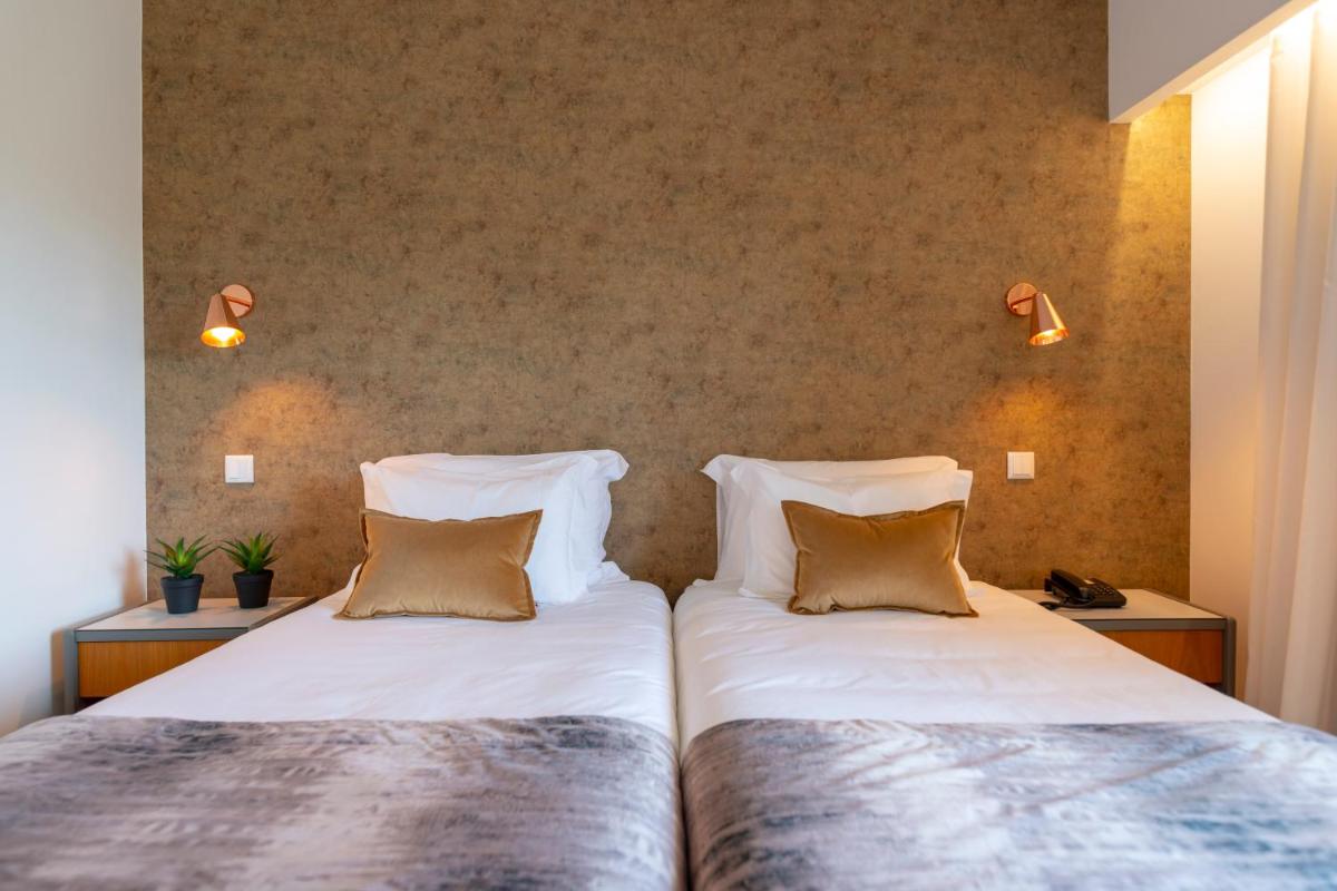 Uma cama ou camas num quarto em D. Afonso Hotel & SPA
