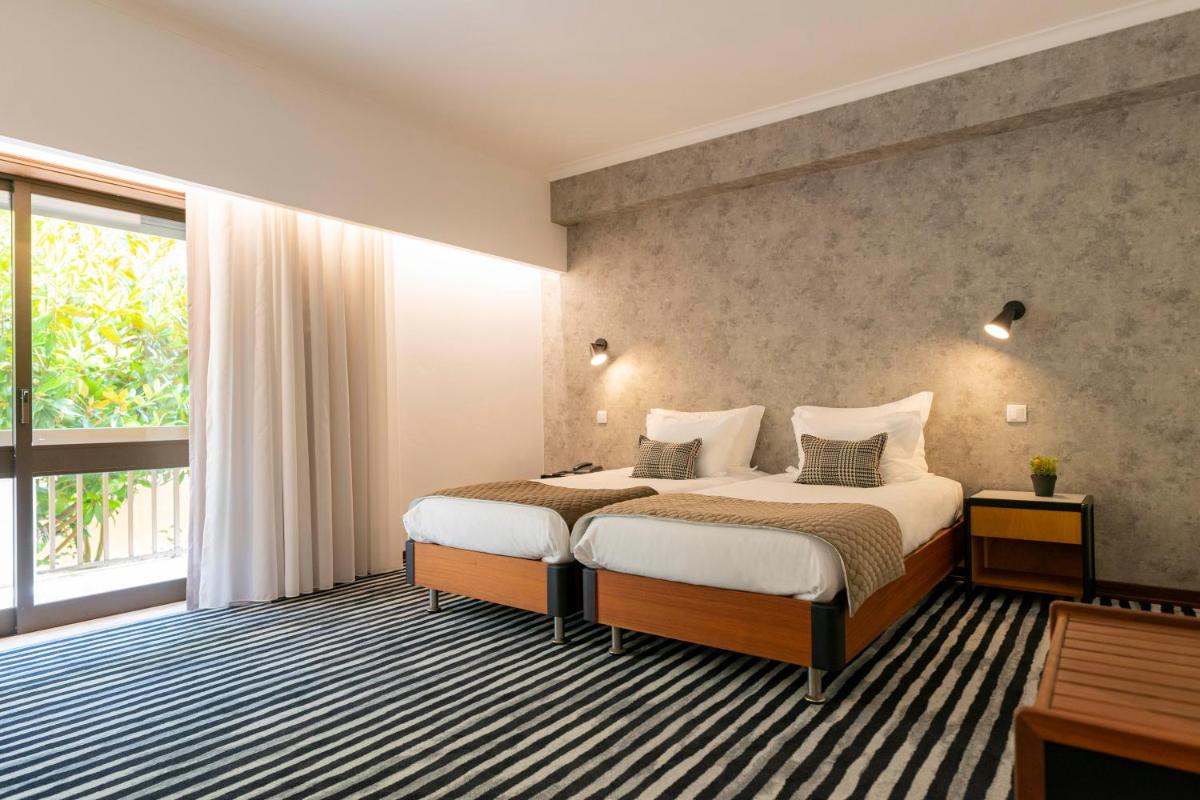 Uma cama ou camas num quarto em D. Afonso Hotel & SPA