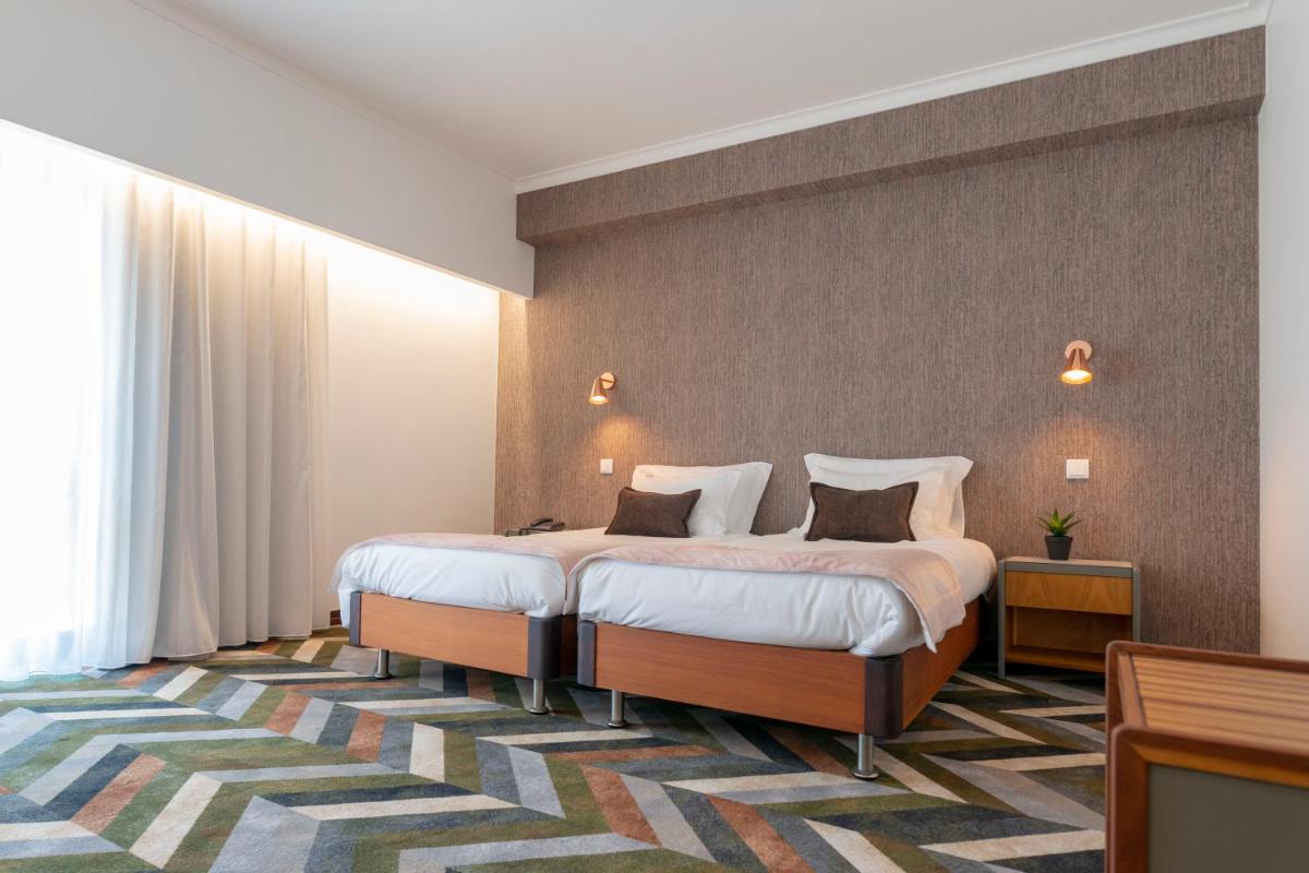 Uma cama ou camas num quarto em D. Afonso Hotel & SPA