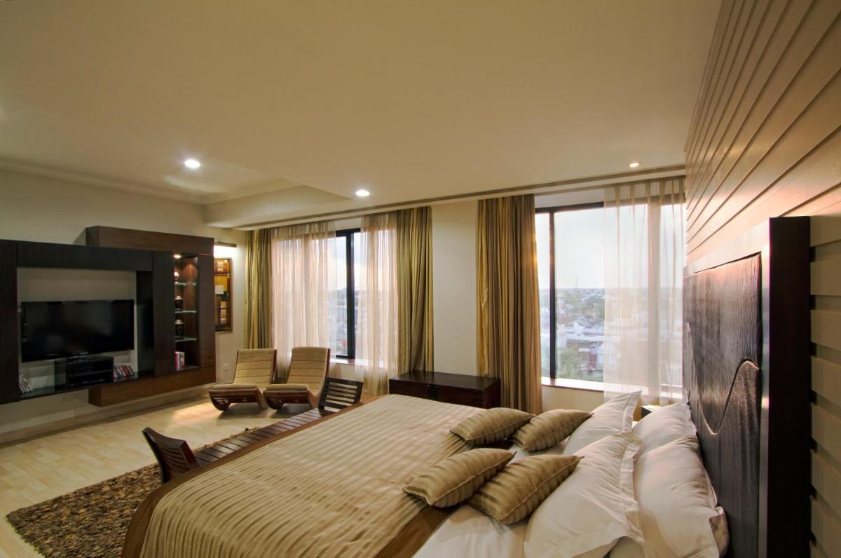 a bedroom with a large bed and a large window at The Piccadily in Lucknow