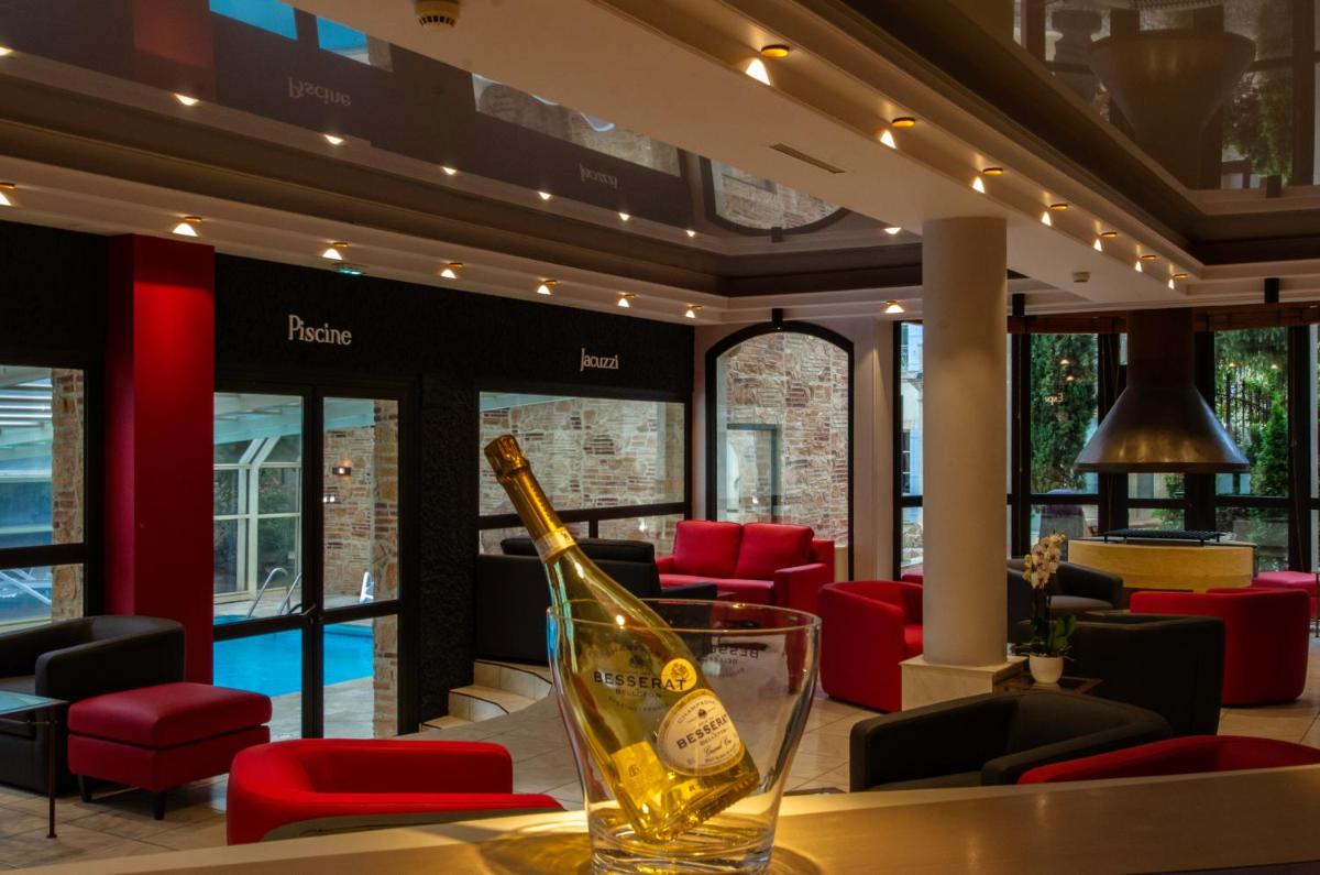 - une bouteille de champagne assise sur une table dans un restaurant dans l'établissement Au Grand Hôtel de Sarlat - Pavillon de SELVES, à Sarlat-la-Canéda