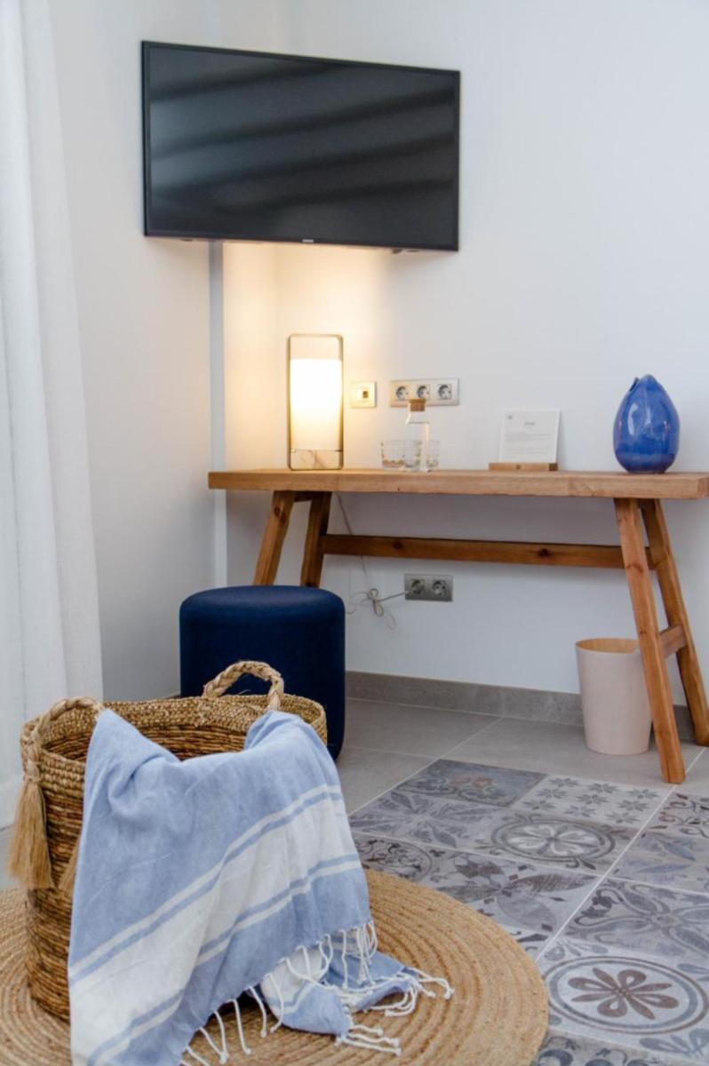 Una habitación con una mesa y una maleta azul. en La Serena Boutique Hotel & Wellness - Altea, en Altea